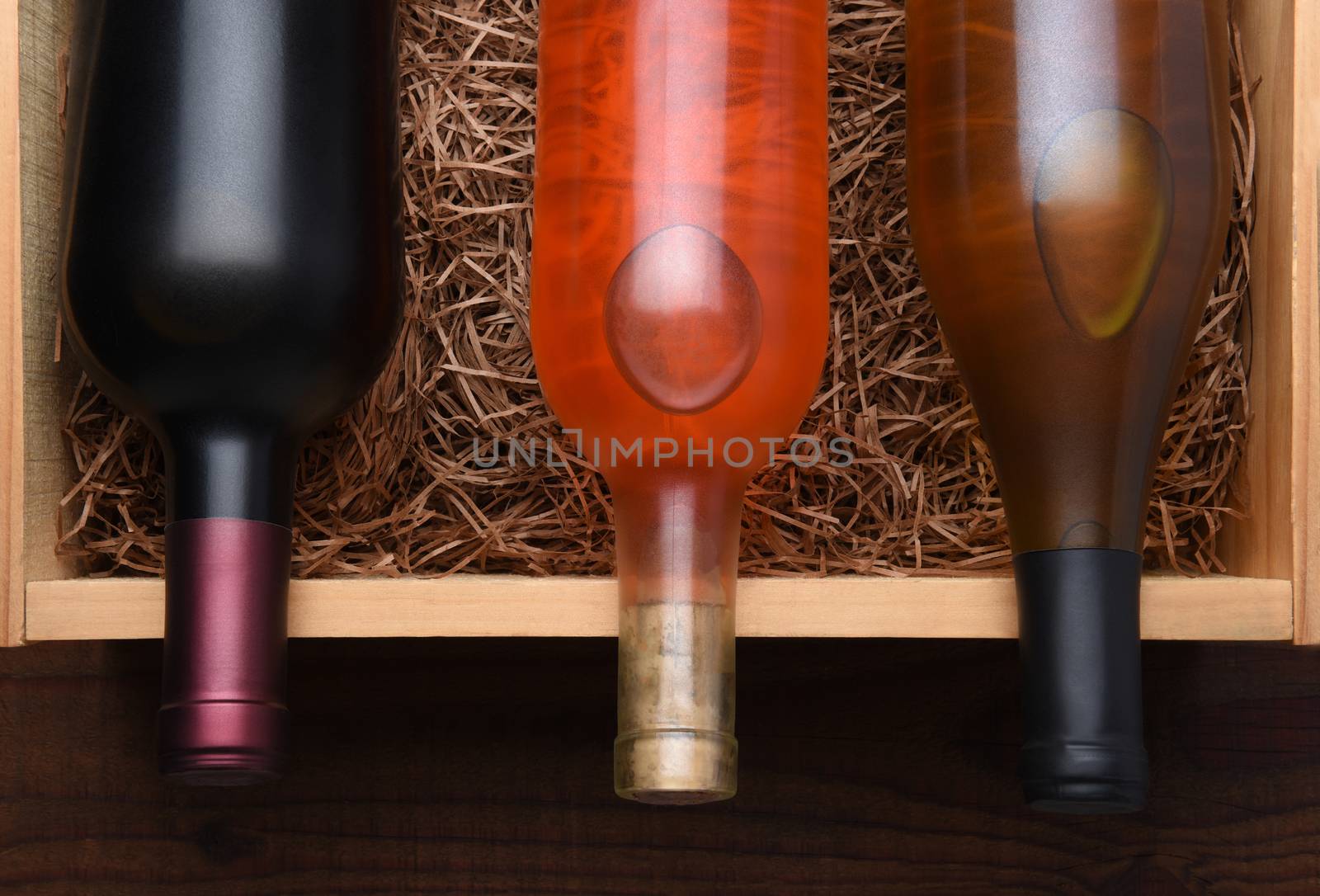 Three Wine Bottles: Bottles of Cabernet, Blush and Chardonnay wine in a wood case with packing straw.