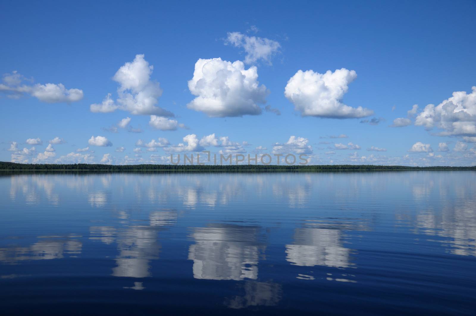 The picture shows typical landscape in the south region of Karelia (blue sky, clouds and a big lake that looks like a mirror)