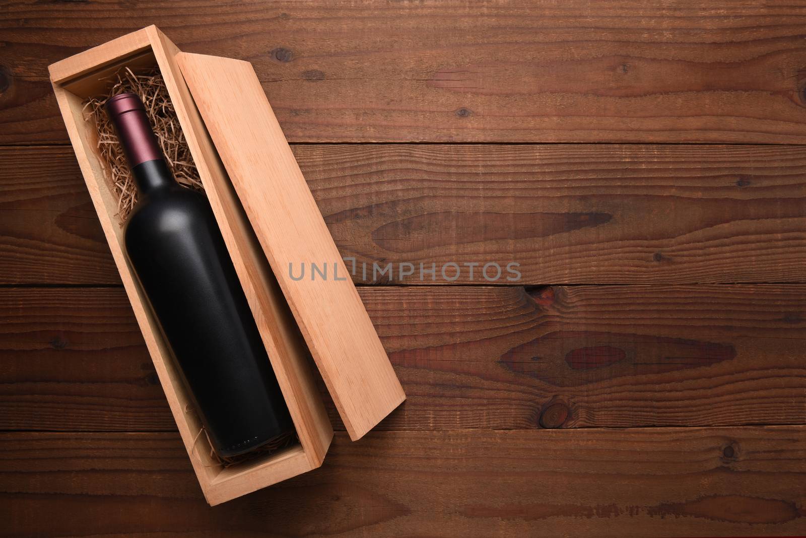 Cabernet Wine Box: A single Bottle of red wine in its wooden case on a dark wood table with copy space.