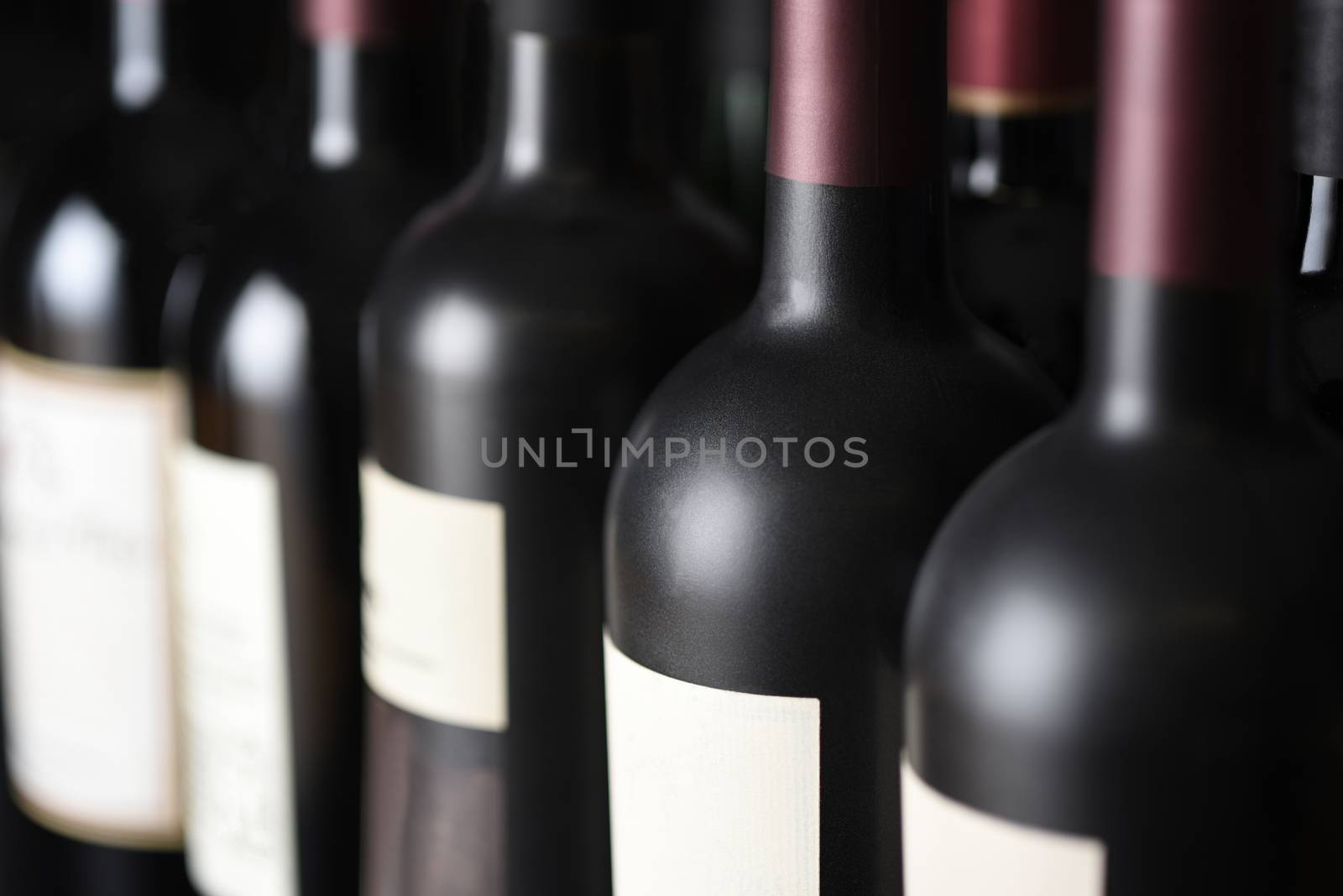 Closeup of a row of vintage wine bottles in a wine cellar. Shallow depth of field. 
