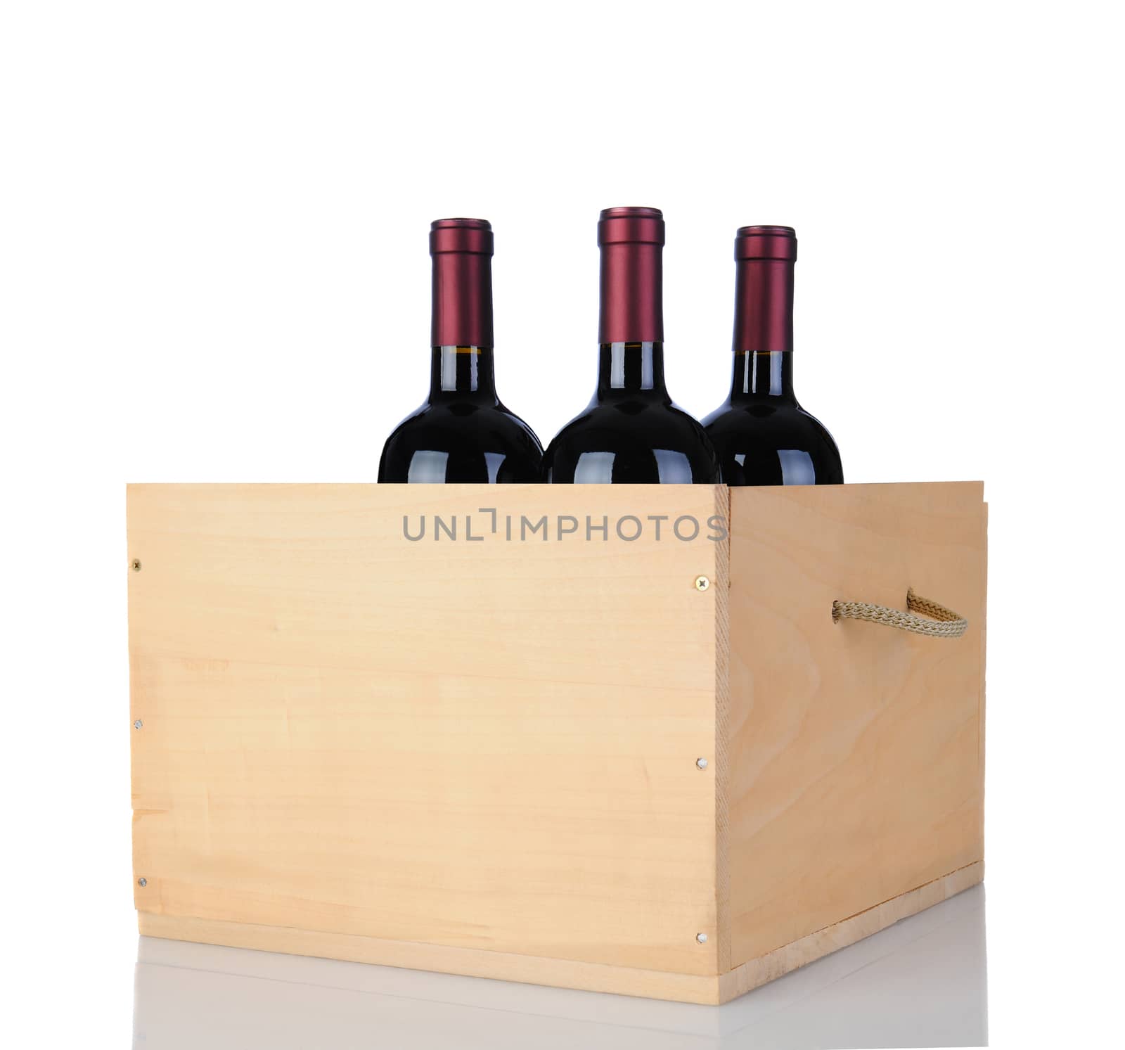 Three Cabernet Sauvignon wine bottles in a wooden crate, isolated on white with reflection.