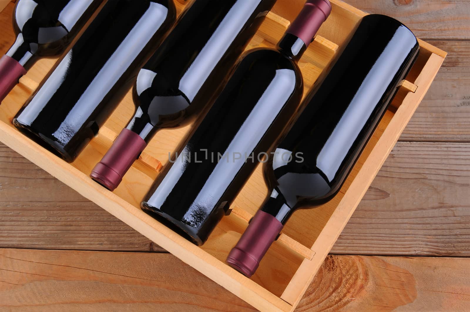 Top view of a case of cabernet sauvignon wine bottles. Horizontal format with a rustic wood background.