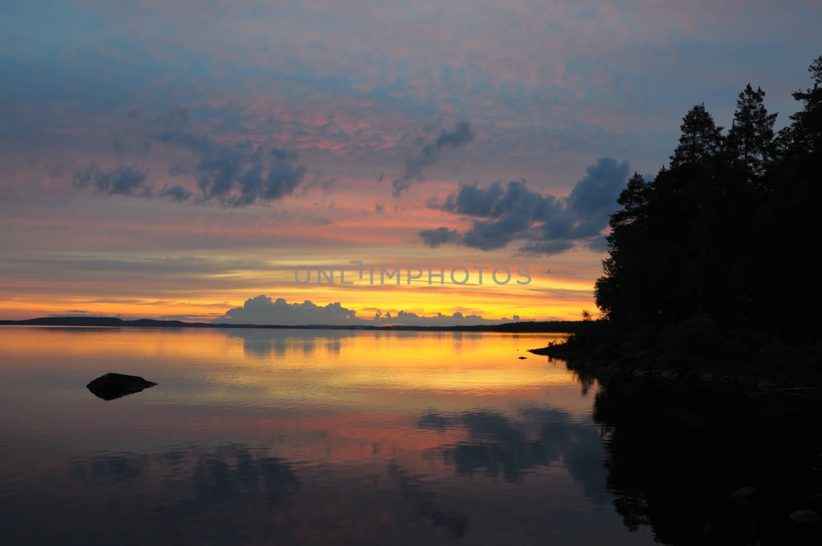 The final stage of a cloudy sunset above the huge lake in Karelia region
