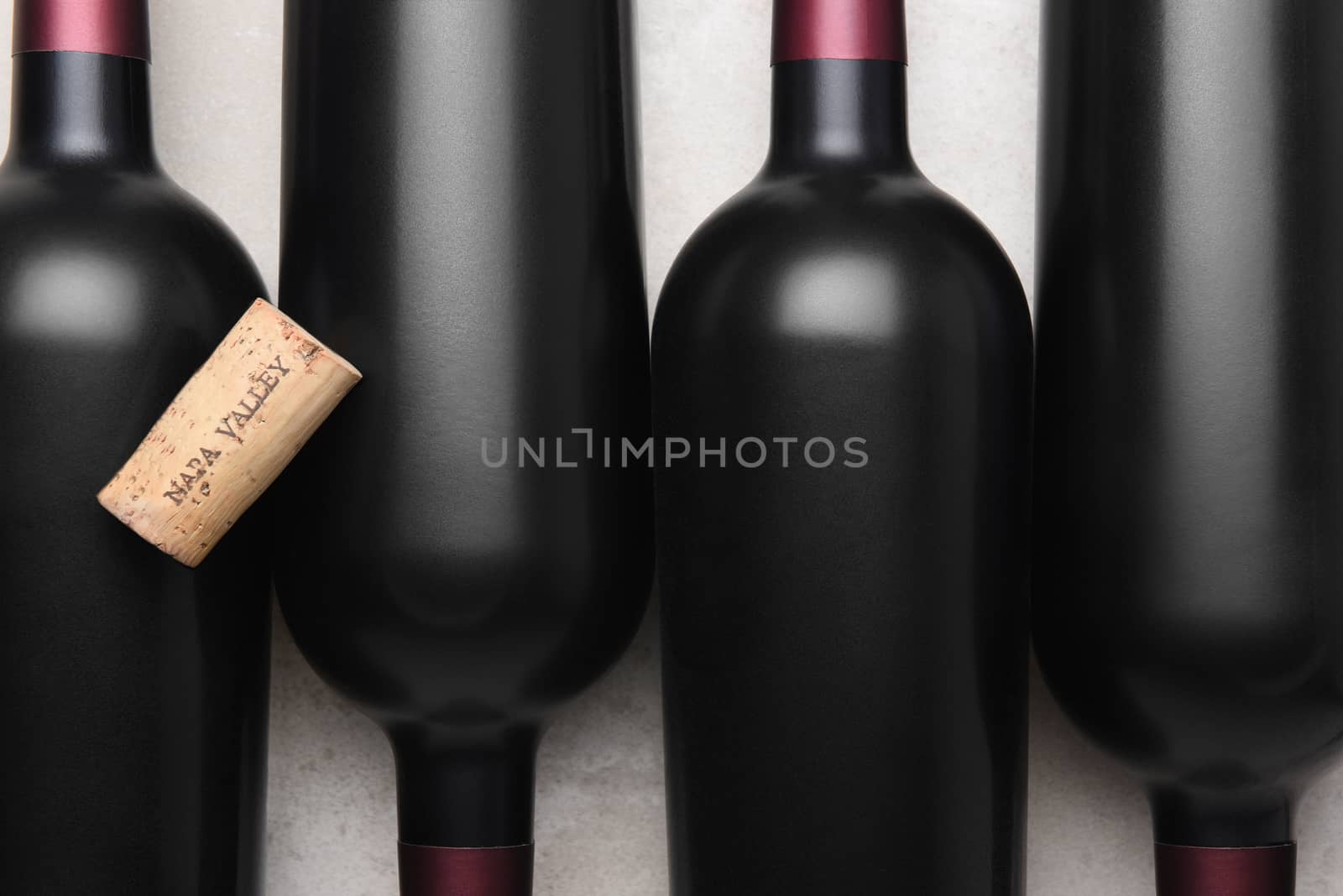 Napa Valley Cork: A wine cork on top of bottles of red wine.