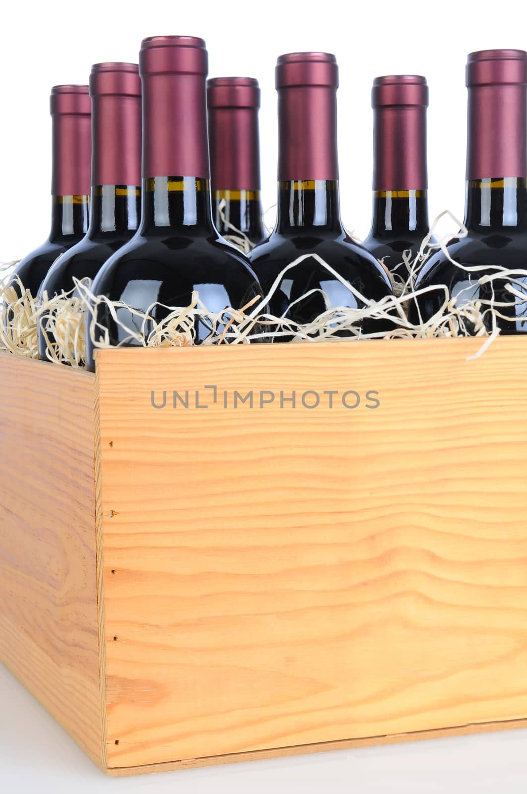 Cabernet Sauvignon wine bottles in a wooden crate. Vertical format isolated on white with reflection.