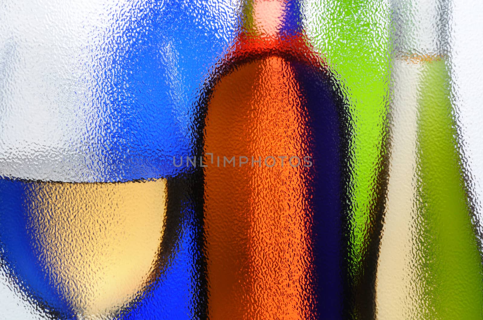 Wine Bottles and Wineglass seen through a textured window with backlight. Horizontal composition.