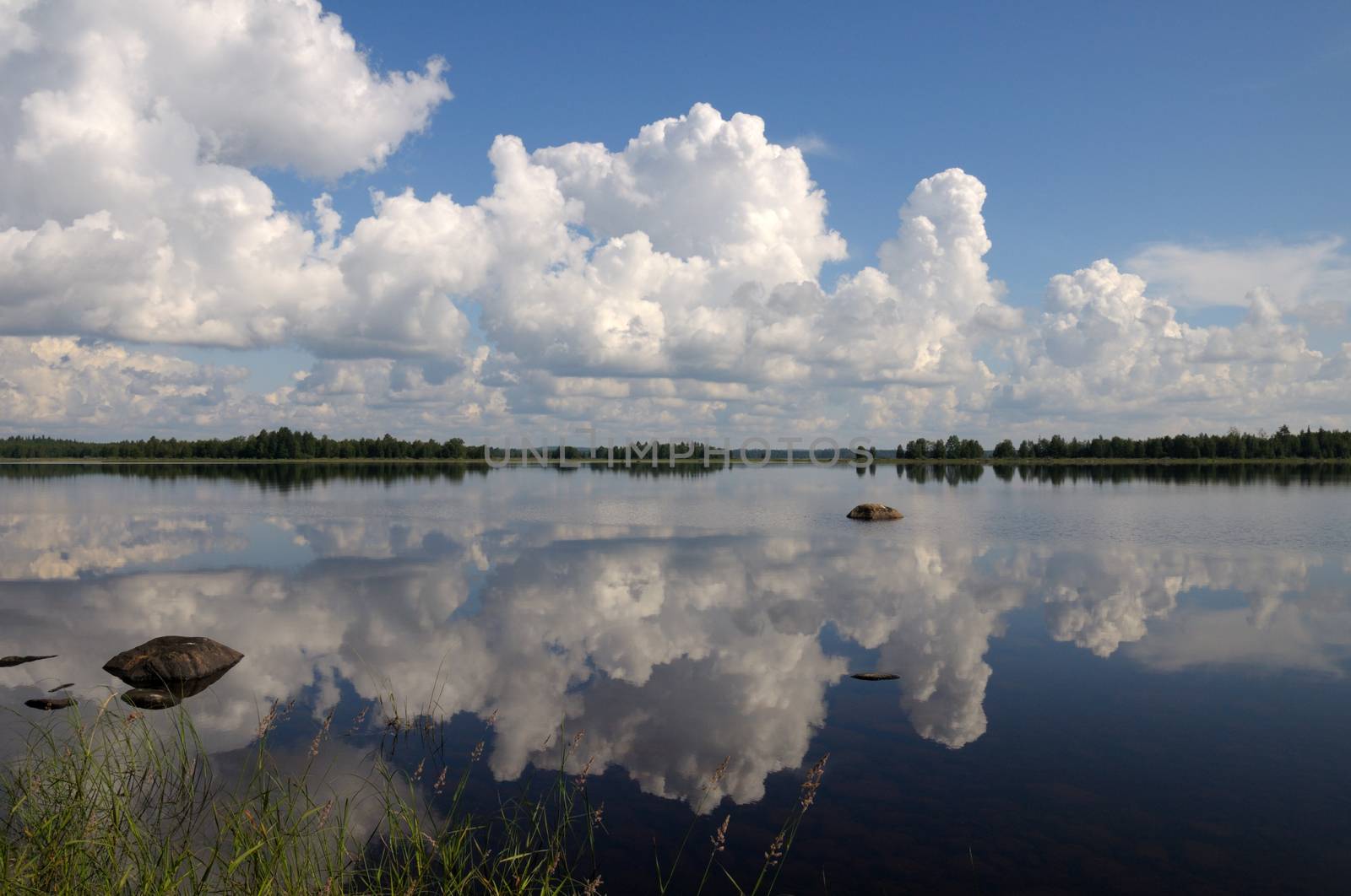 Blue sky and small clouds above the mirrored big lake by nemo269