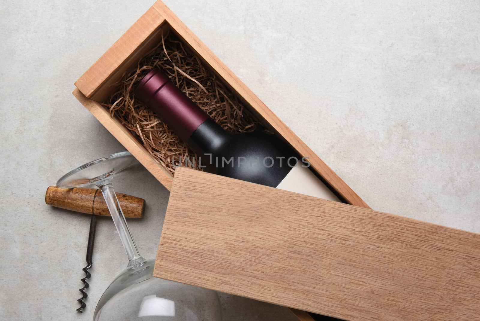 Cabernet Wine Box: A Red wine bottle in a wood box partially covered by its lid with a glass and corkscrew. 