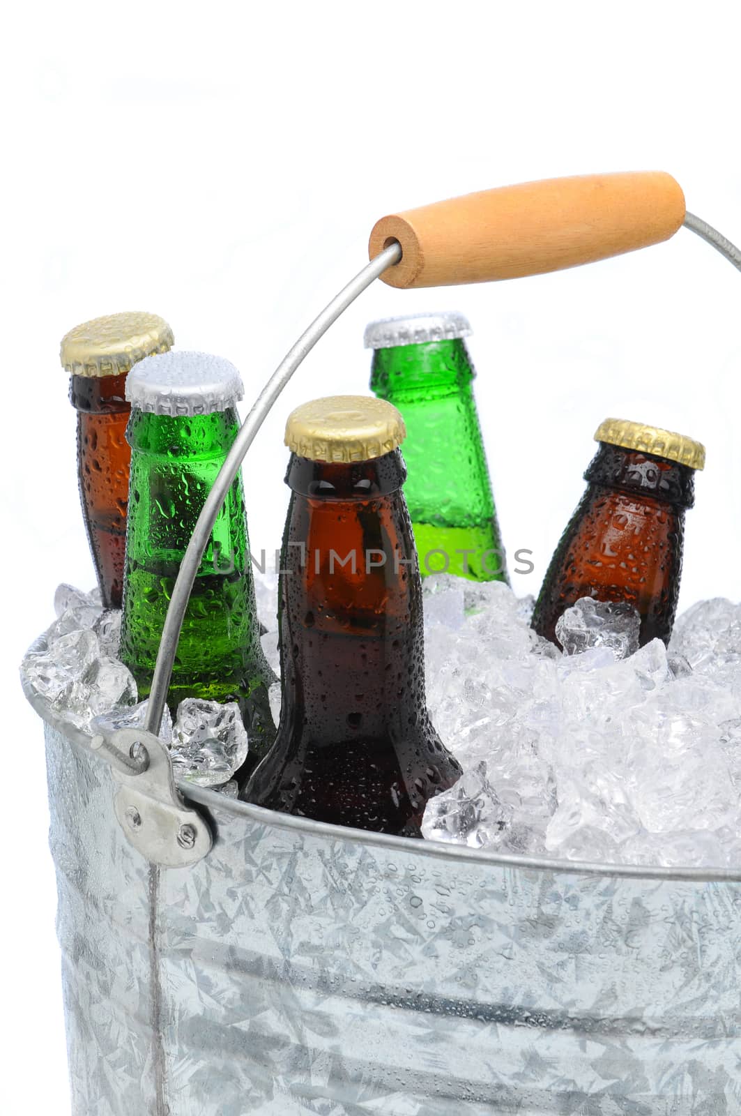 Closeup of a bucket  filled with ice cubes and an assorted beer bottles on a white background.