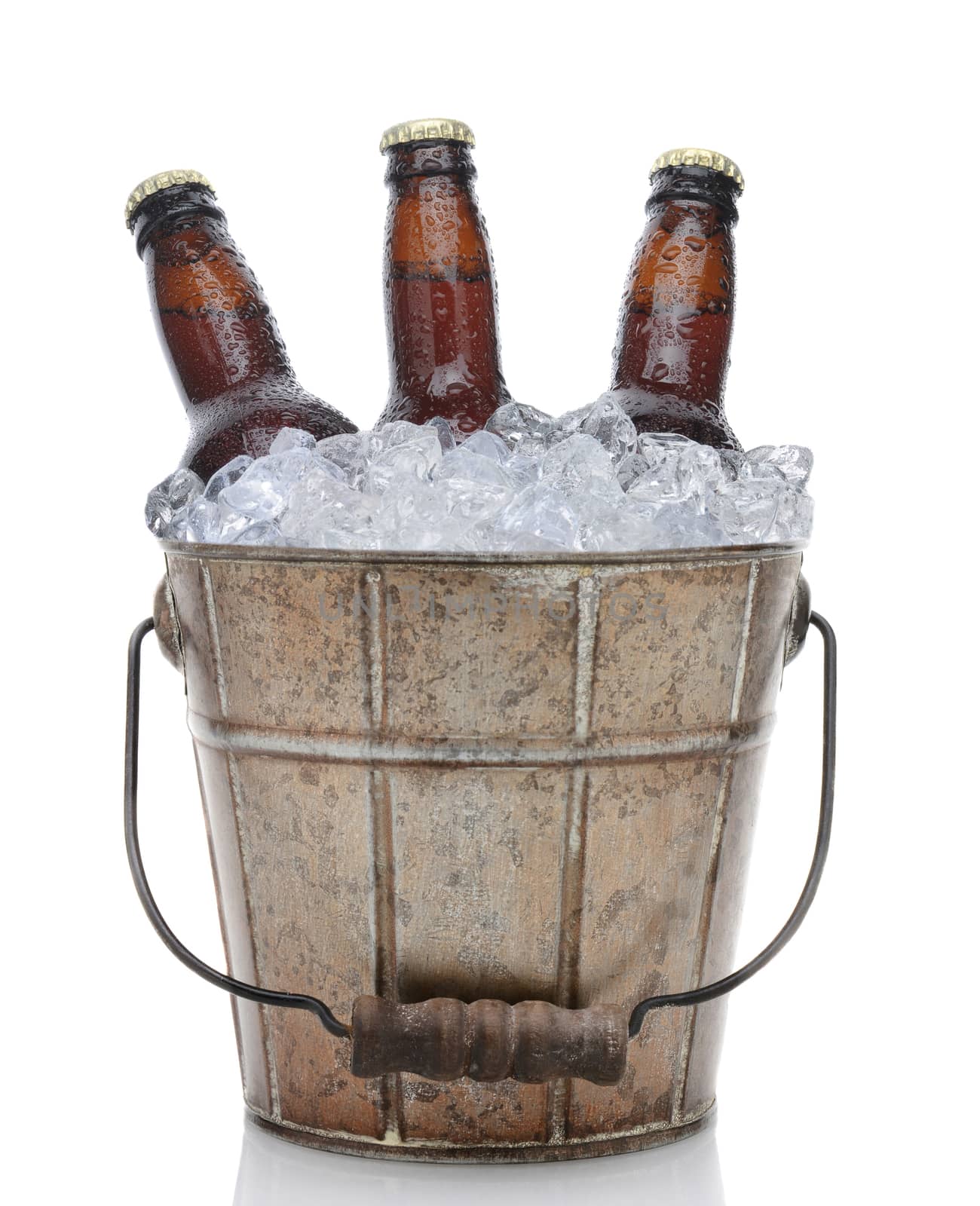 Closeup of an old fashioned beer bucket with three brown bottles of cold beer. Isolated on white with reflection.