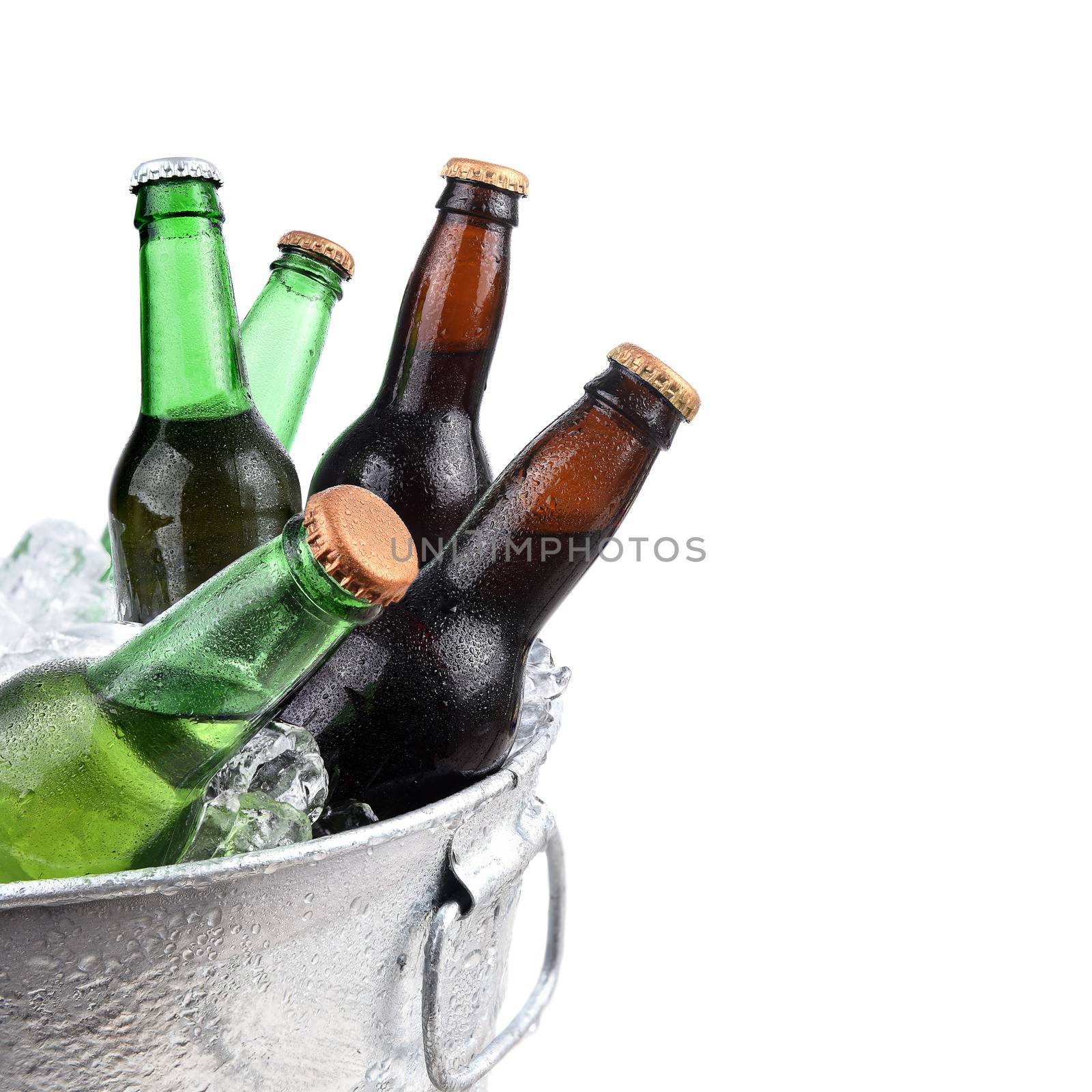 Closeup of green and brown beer bottles in a metal ice bucket, isolated on white.