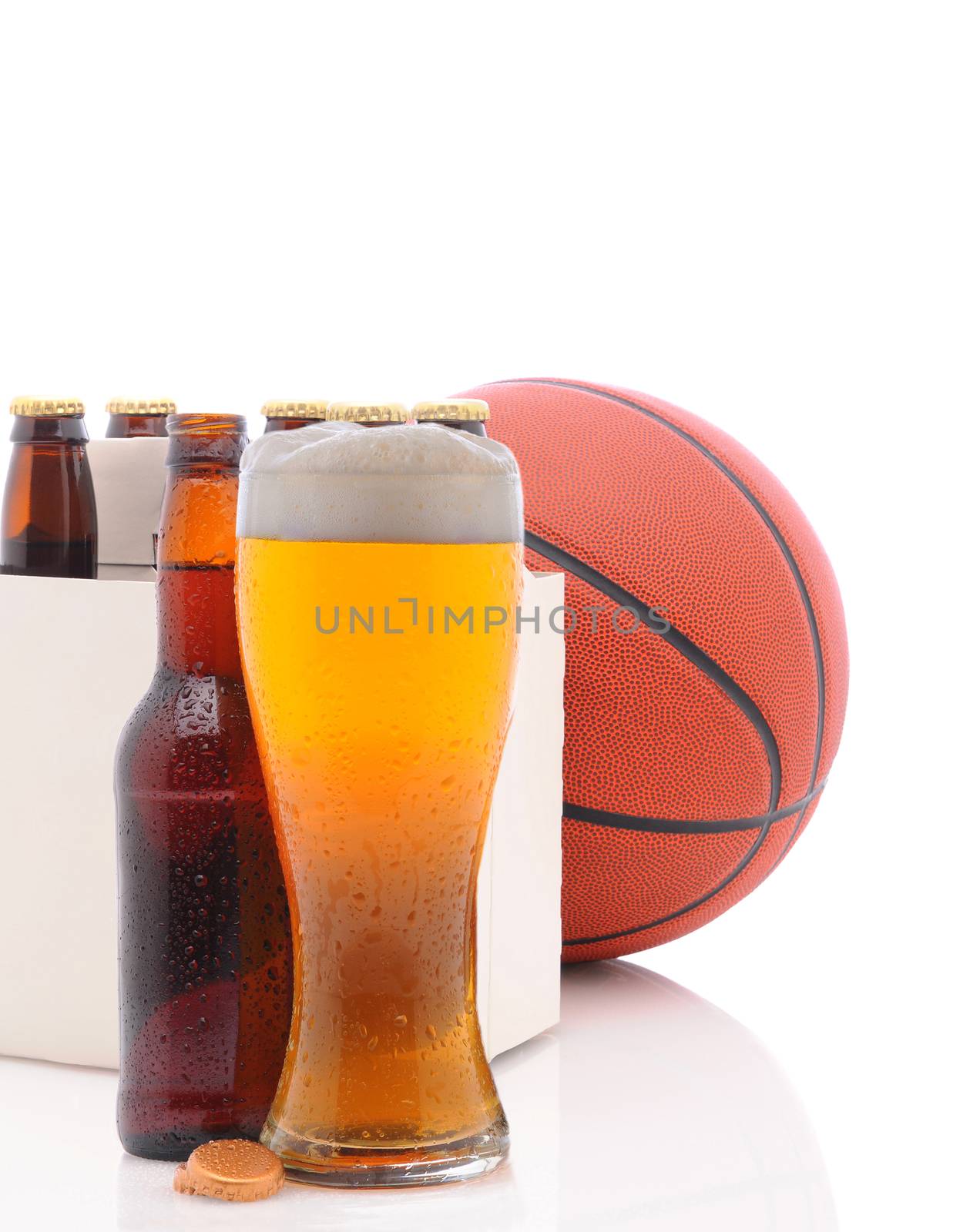 A Basketball Six Pack of Beer Bottles and a Glass of Ale on a white background with reflections in the foreground.