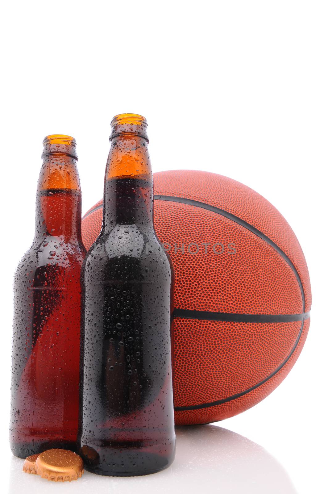 Two open beer bottles and a basketball on a white background with reflection. Vertical format from a low angle.