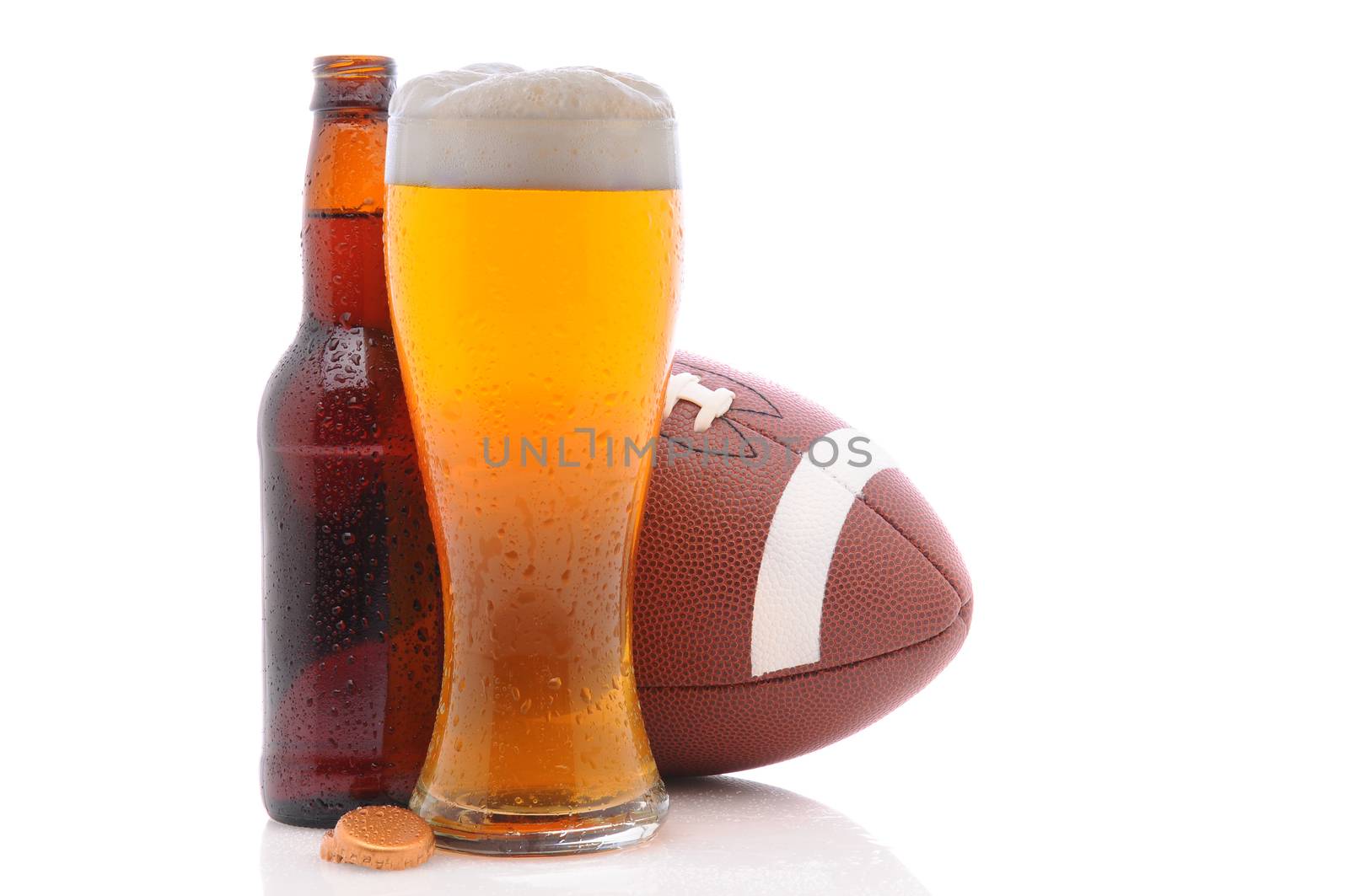 American Football behind a bottle and glass of beer with condensation. Horizontal format on a white background with reflection. 