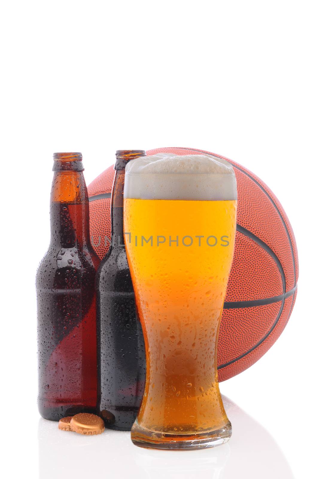 Two open beer bottles and a glass with a basketball on a white background.  Vertical format from a low angle with reflection. 