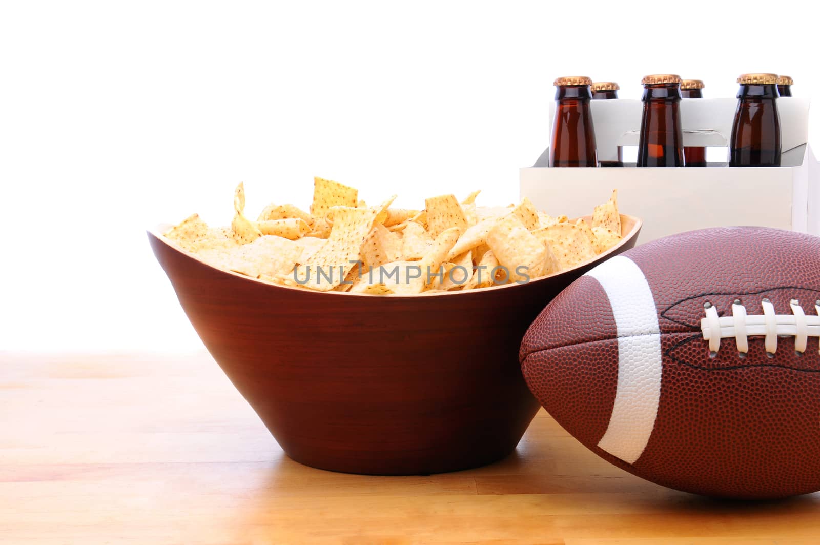 Chips, football and Six Pack of Beer on a table with a white background. Horizontal format.
