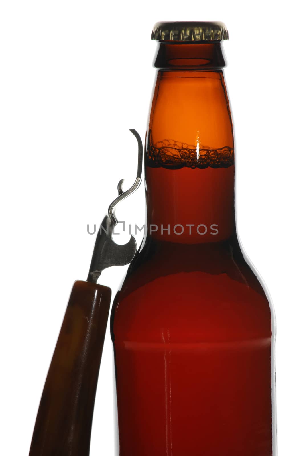 Brown beer bottle with opener leaning against the side of the bottle, isolated over white.