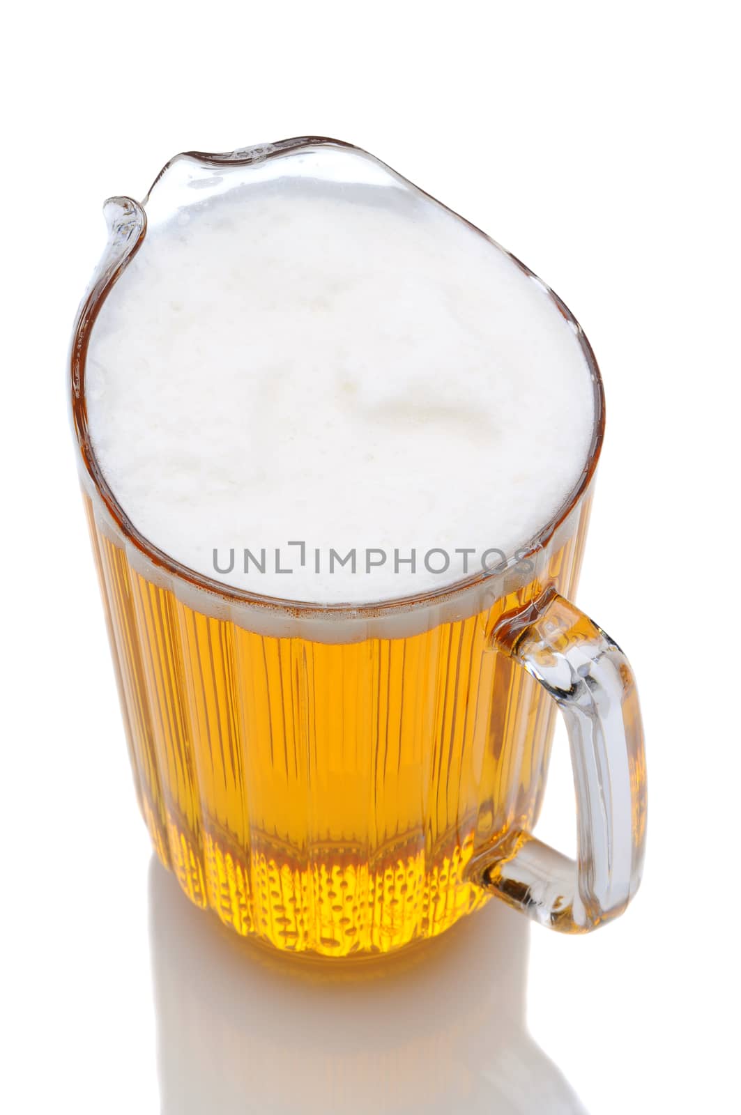 A pitcher of beer shot from a high angle over a white background with reflection.