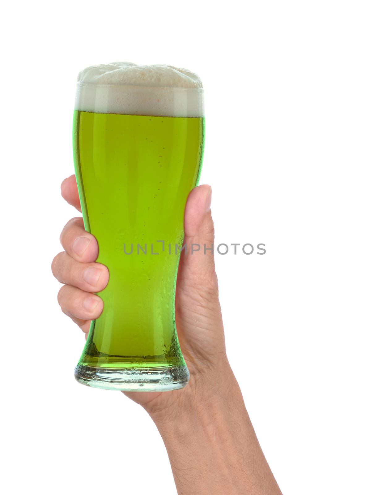 Man's hand holding up a glass of foamy green beer to celebrate St. Patrick's Day. Vertical format over a white background