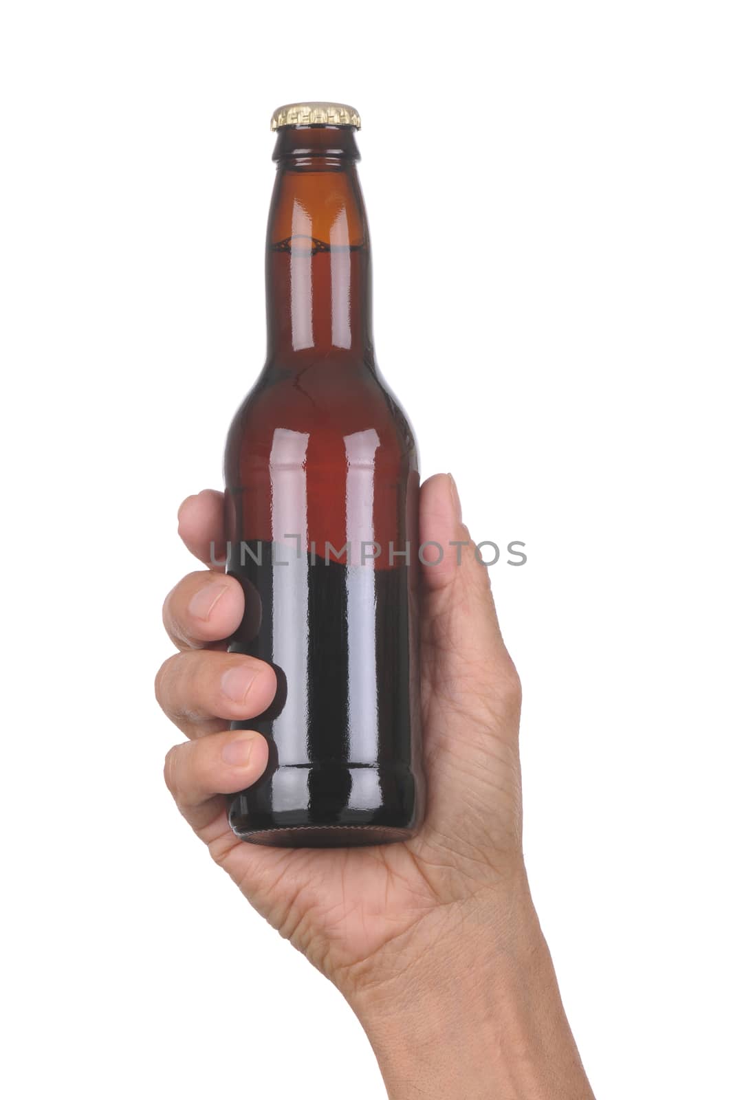 Man's hand holding up a brown beer bottle without label over a white background vertical format