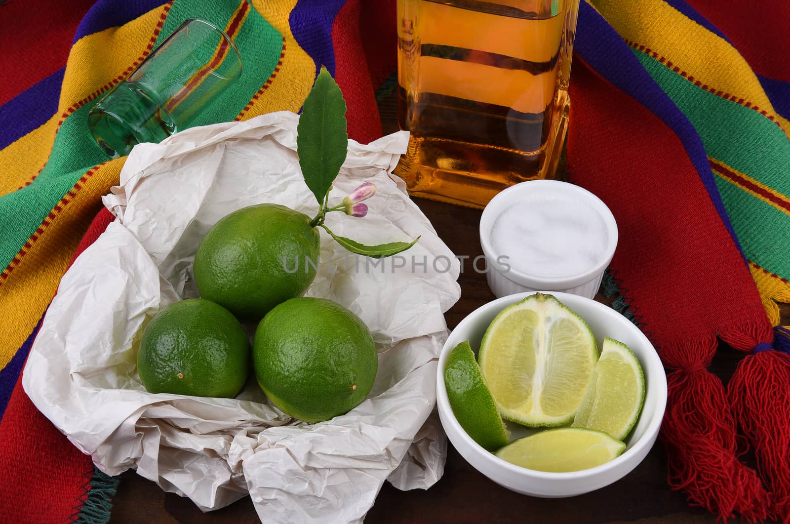 Tequila shot with limes, salt, Mexican blanket. Great for Cinco de Mayo themed projects or Mexican restaurants.