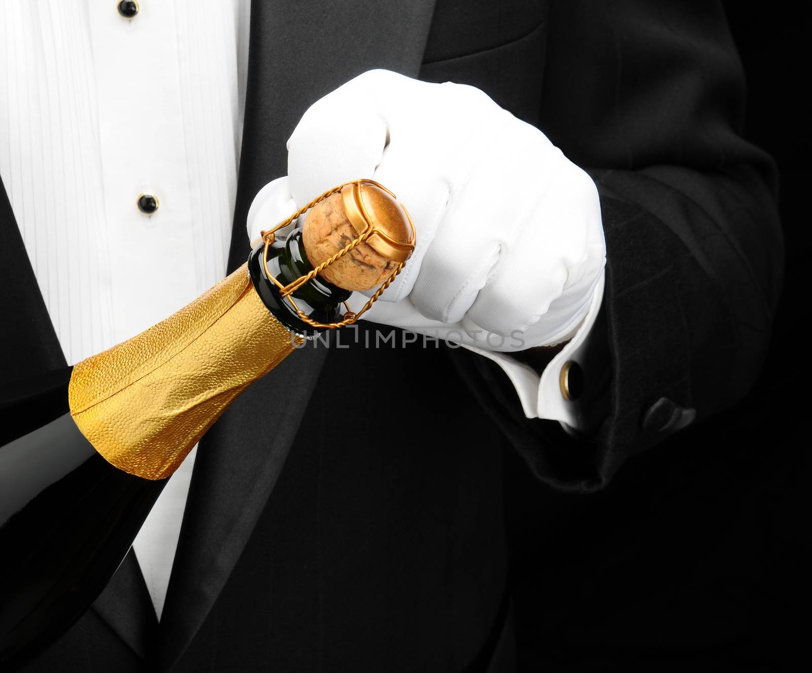 Closeup of a waiter opening a bottle of champagne.