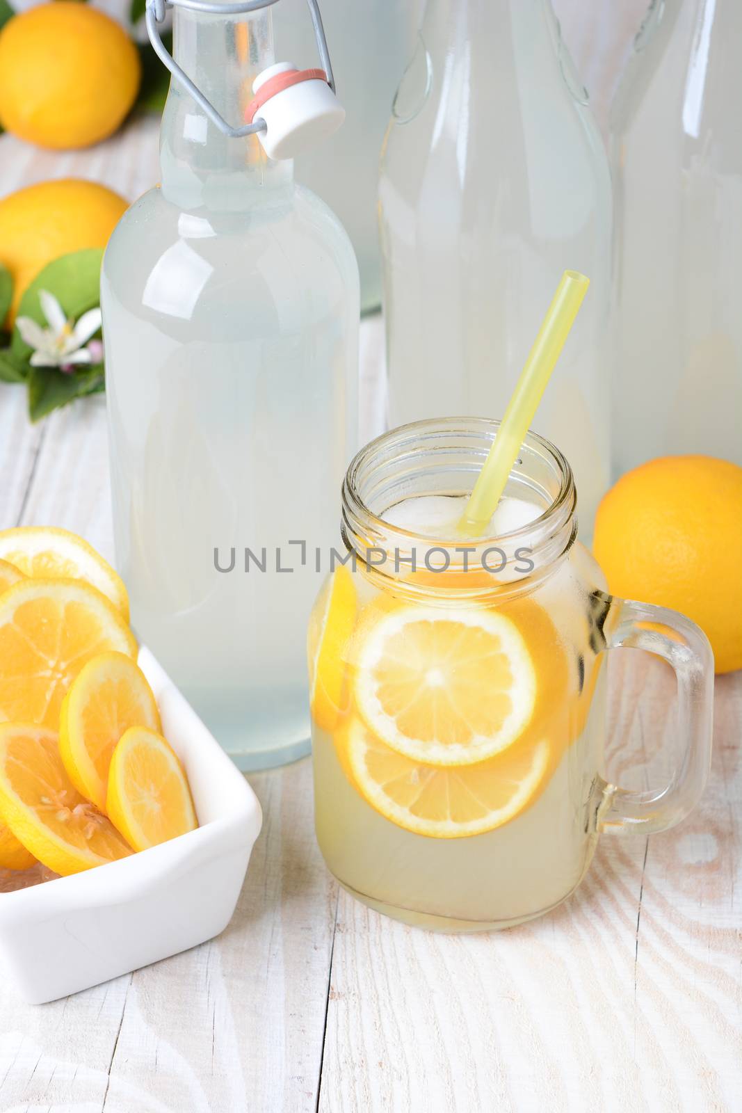 Old fashioned sparkling lemonade shot from a high angle. Vertical format on a rustic wooden farmhouse style table.