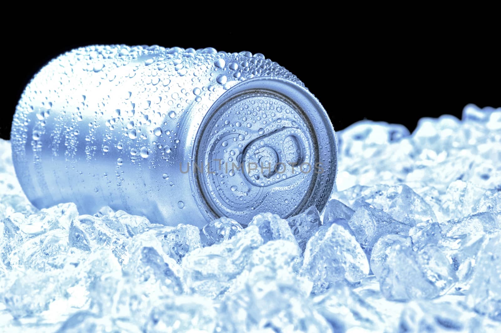 Aluminum Drink Can with water droplets laying in a bed of ice - black background and cool tones