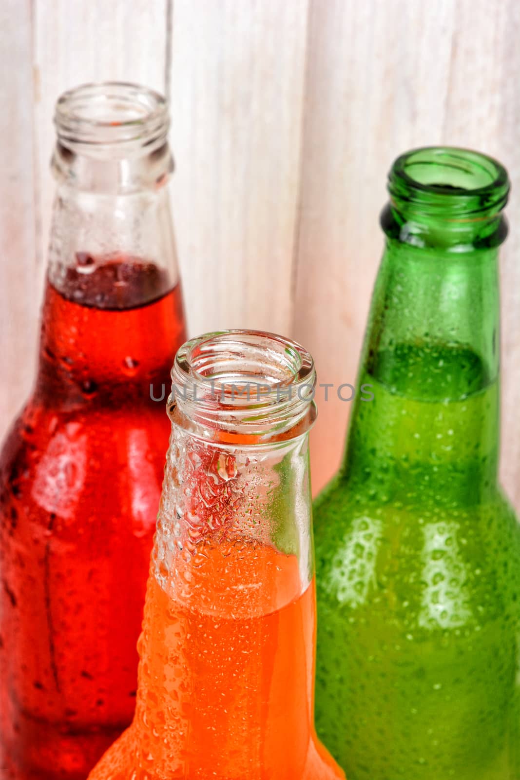 Closeup of soda bottle necks with condensation.