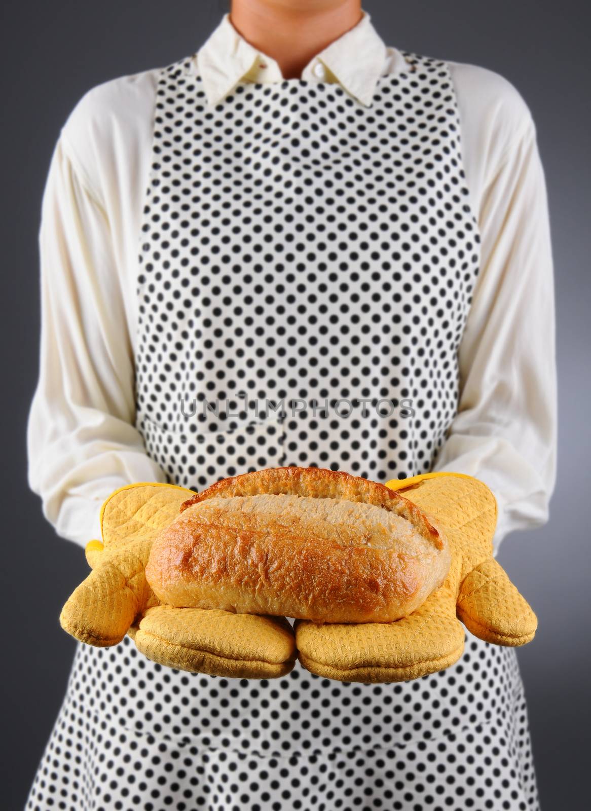 Homemaker Holding Fresh Loaf of Bread by sCukrov