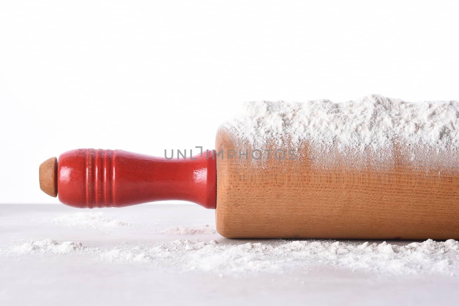 Closeup of a rolling pin with flour  by sCukrov