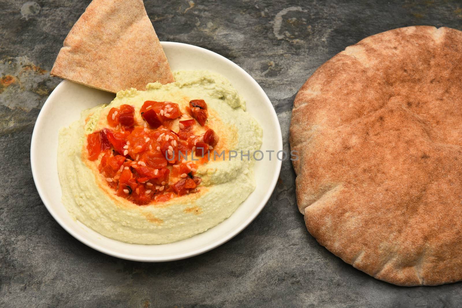 Top view of a bowl of edamame Hummus and pita bread. Horizontal format.