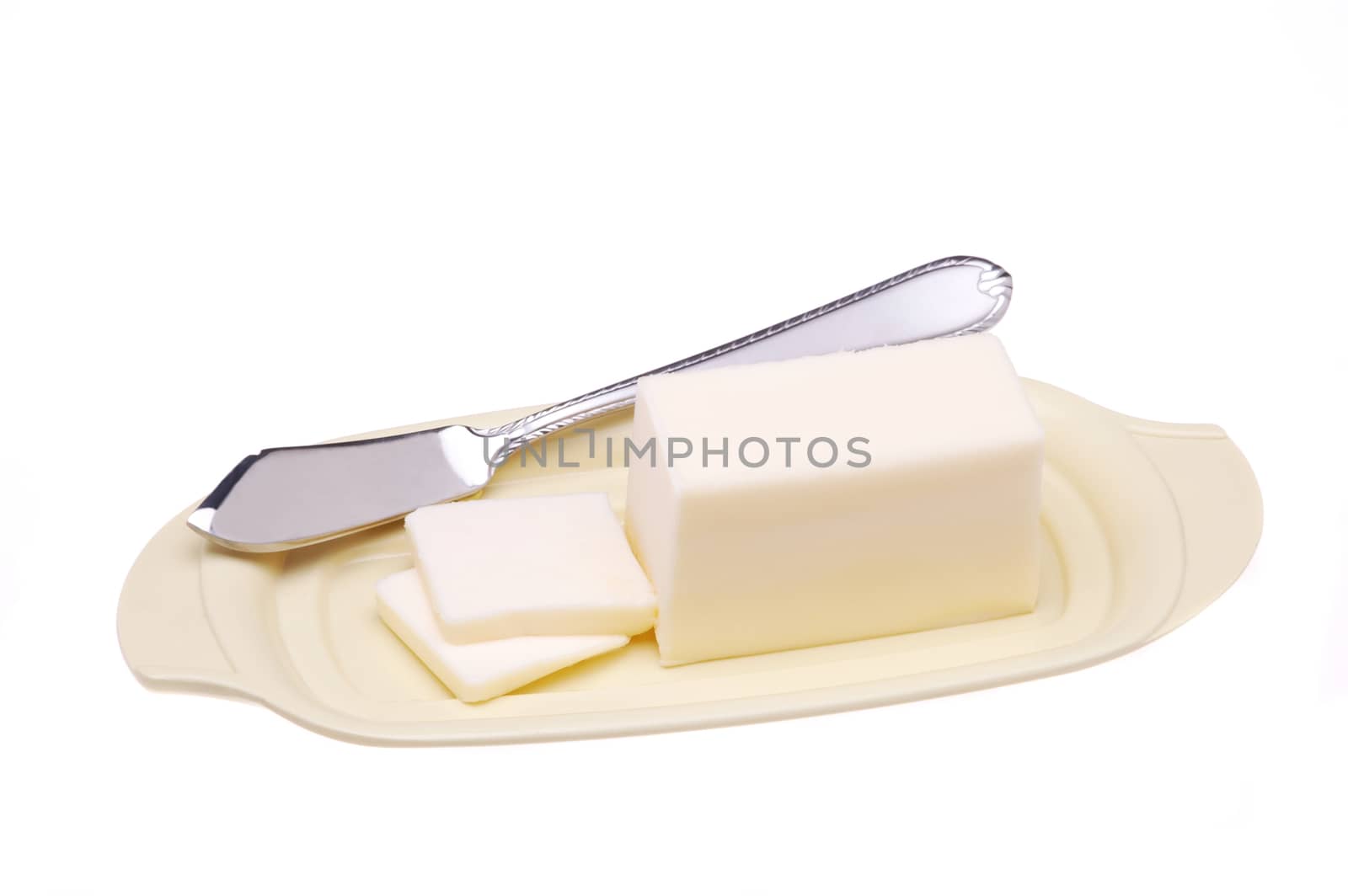 Stick of Butter and Knife on Plate with two pats cut isolated over white