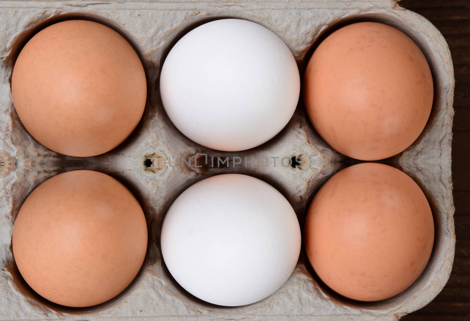 High angle view of a carton of brown and white farm fresh eggs. 