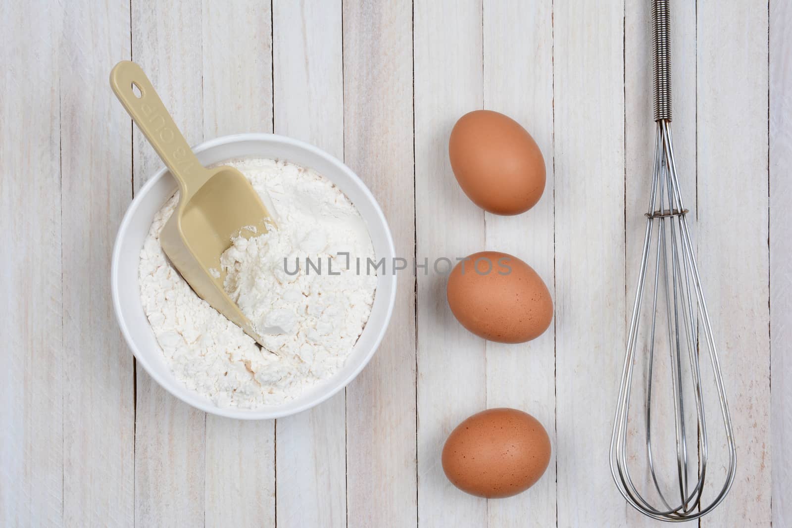 Bowl of Flour Eggs and Whisk by sCukrov