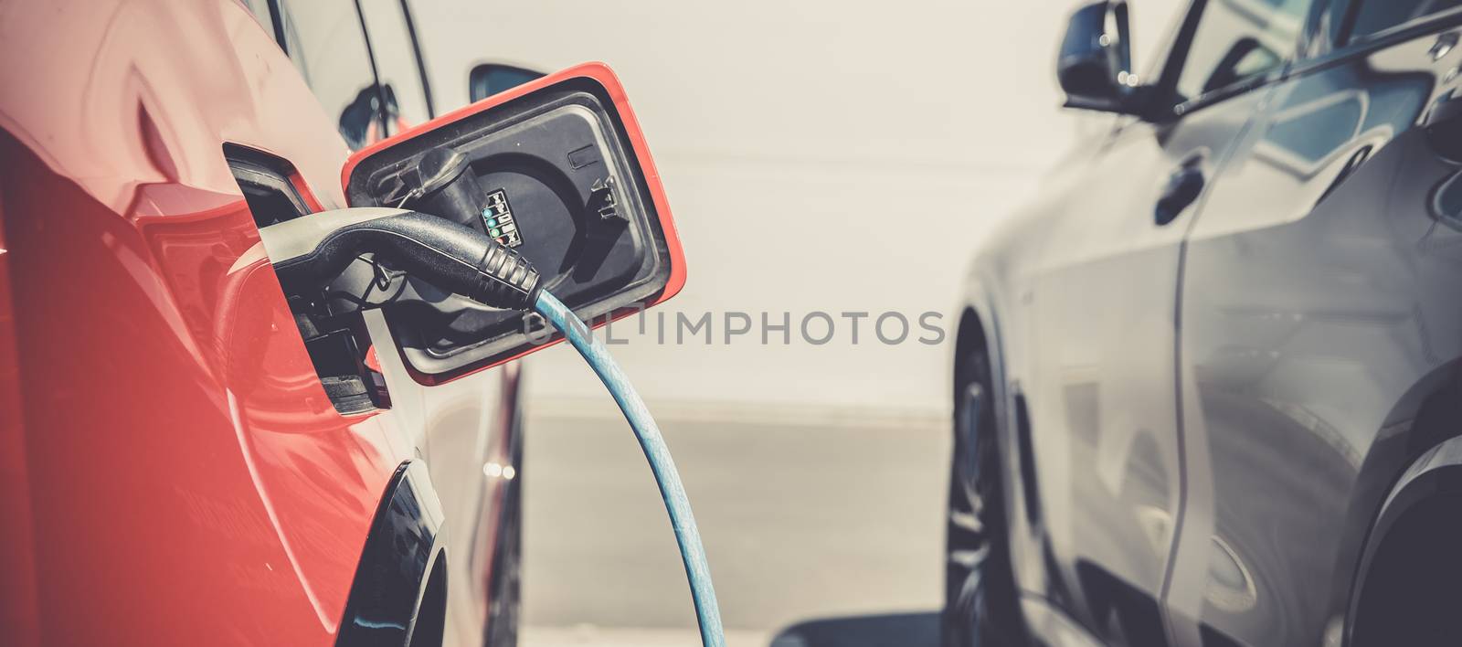 charging an ecological car with an electric motor at the charging station by Edophoto