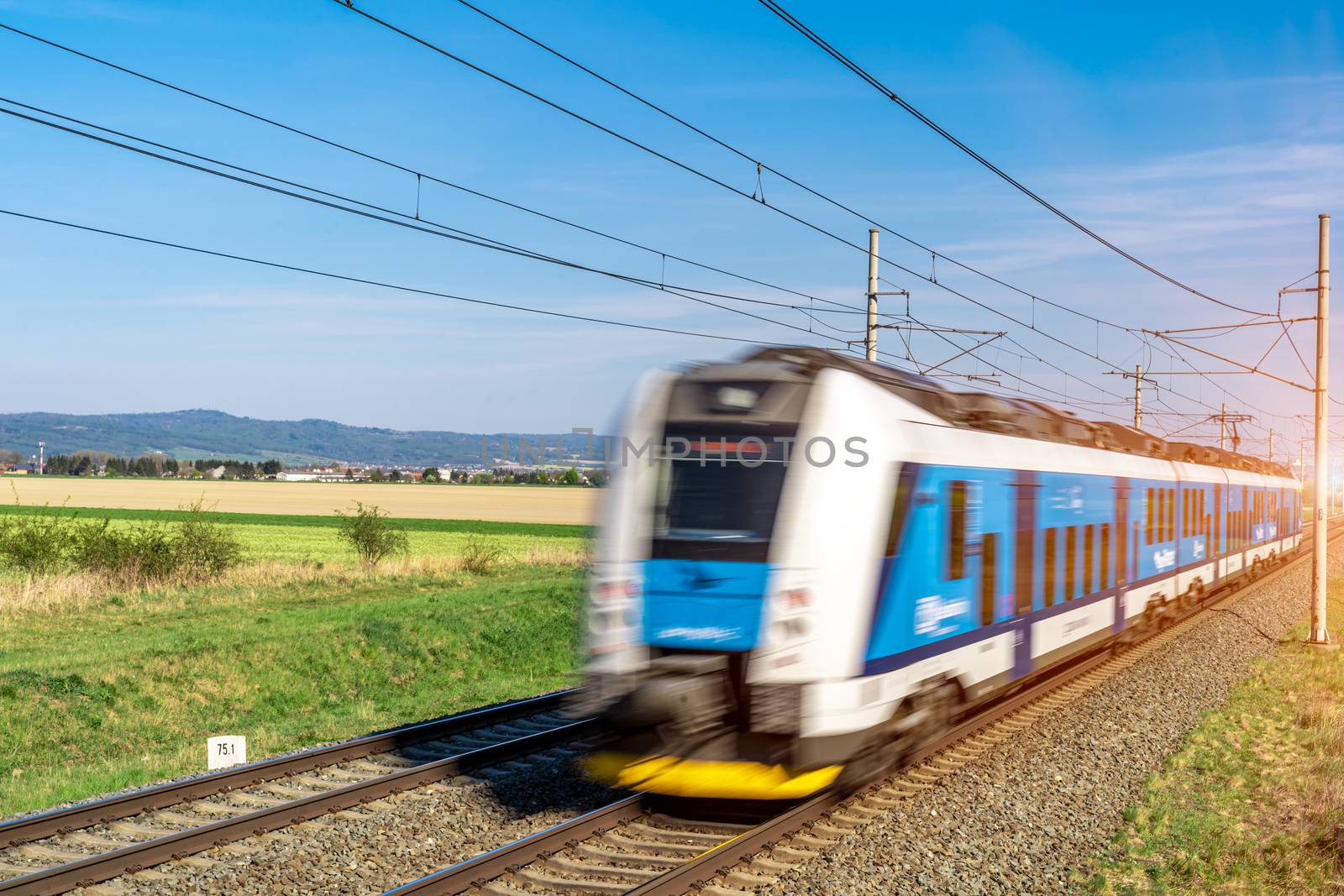 an electric train passes through a beautiful landscape on railway tracks.