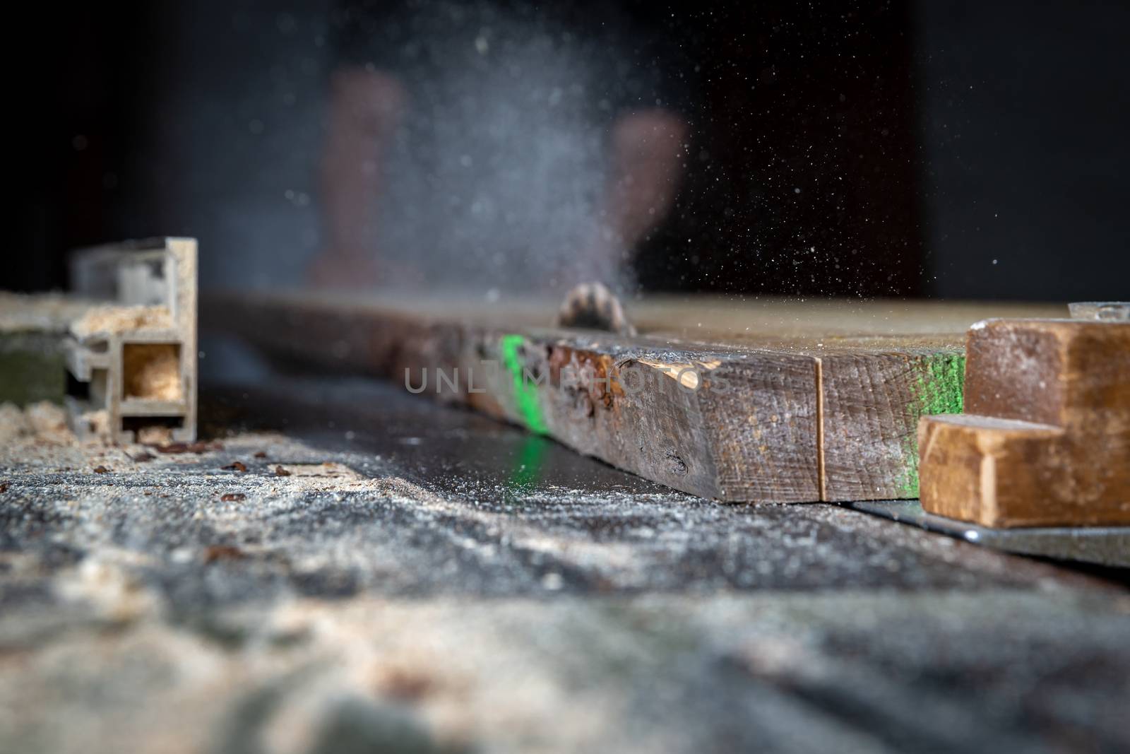 A man cuts wood on a circular saw in a joinery.