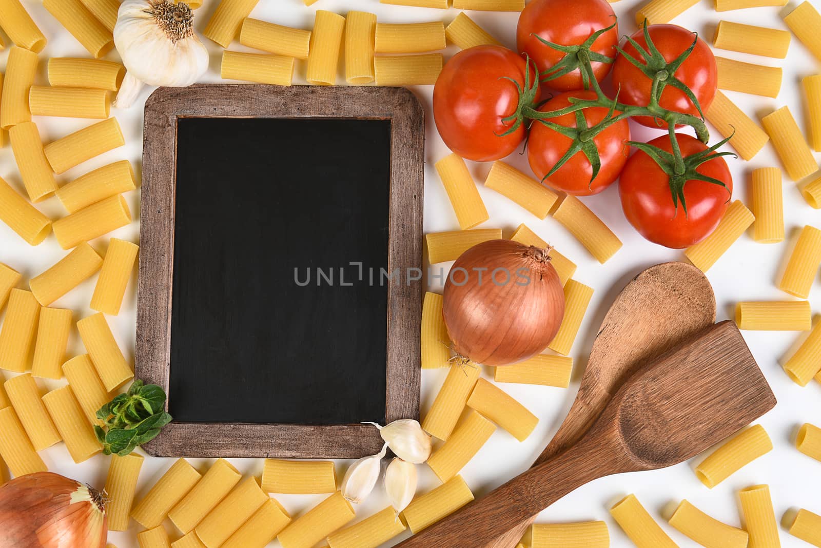 Top view of a blank chalkboard with the ingredients for an Italian meal. Horizontal format.