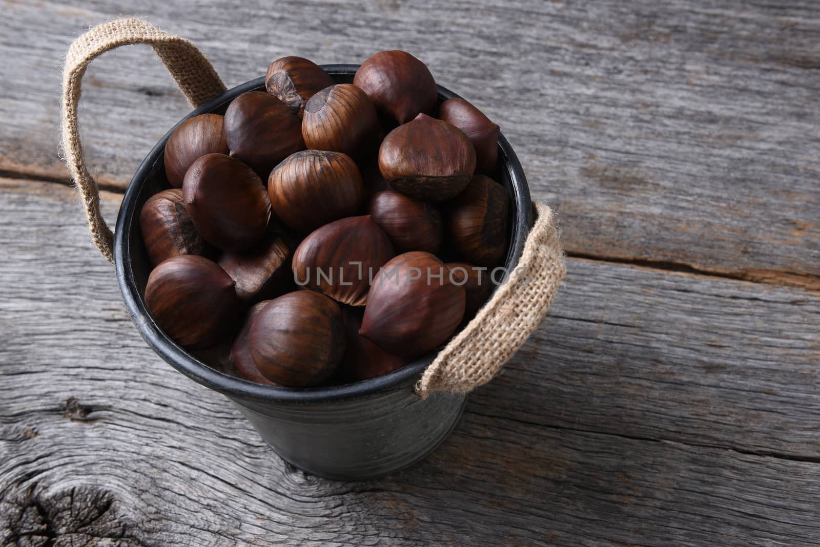 A bucket full of fresh raw Chestnuts.