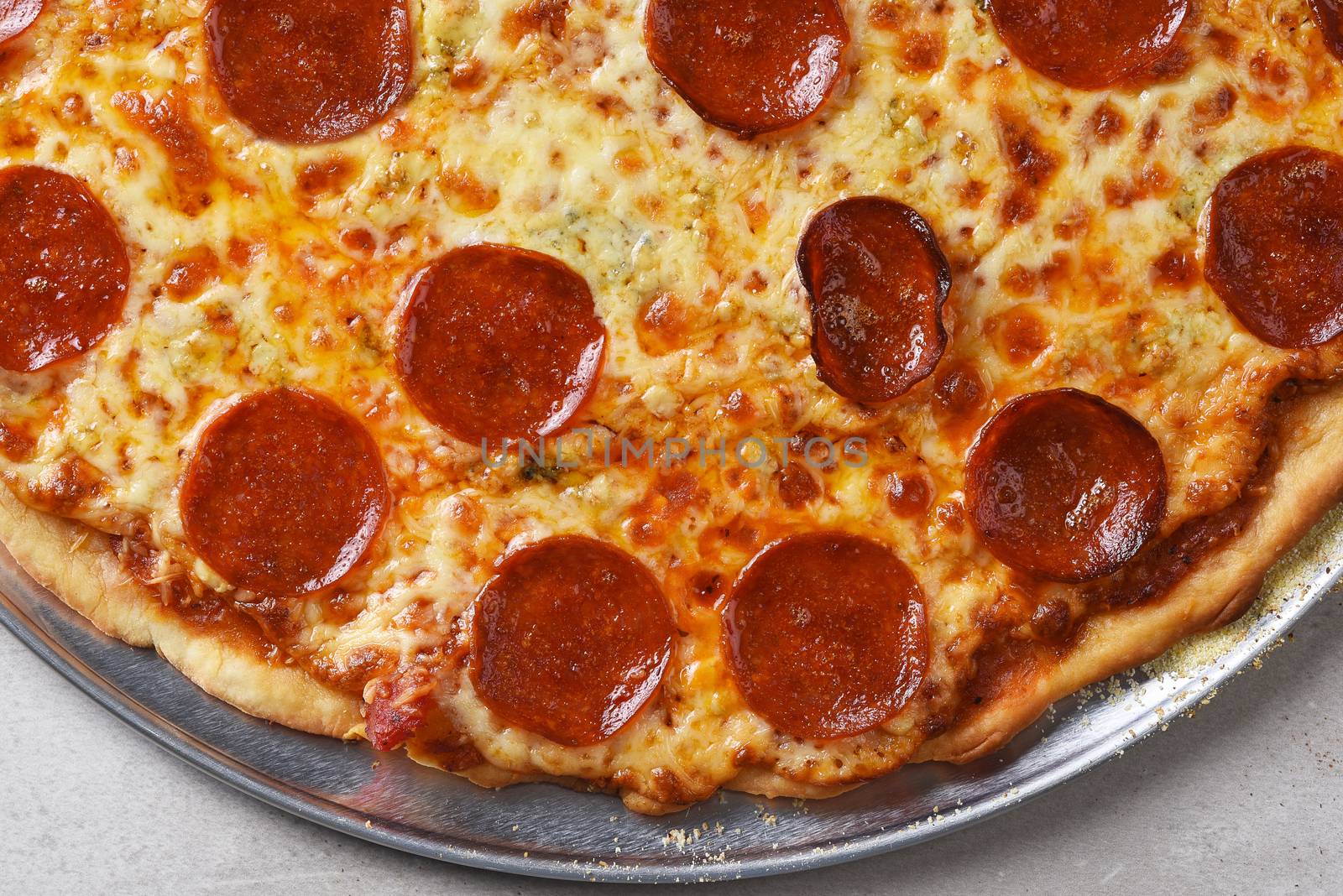 Closeup of a fresh homemade three cheese pepperoni pizza, made with Parmesan, Mozzarella, and Gorgonzola.