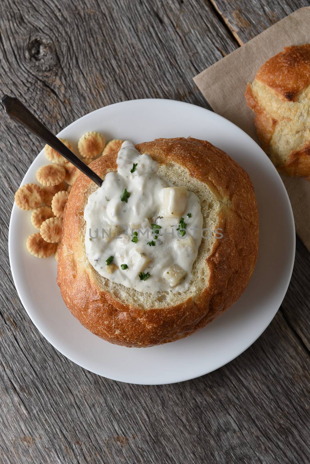 Overhead view of a bread bowl of New England Style Clam Chowder by sCukrov
