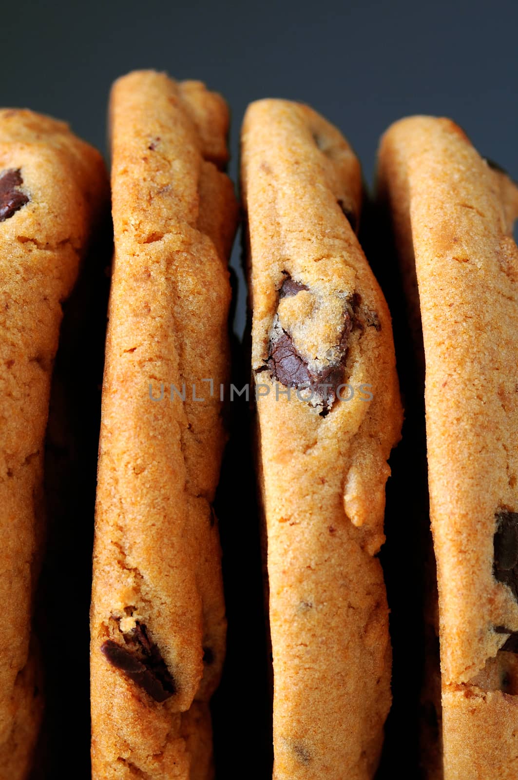 Closeup of chocolate chip cookies standing on their sides.