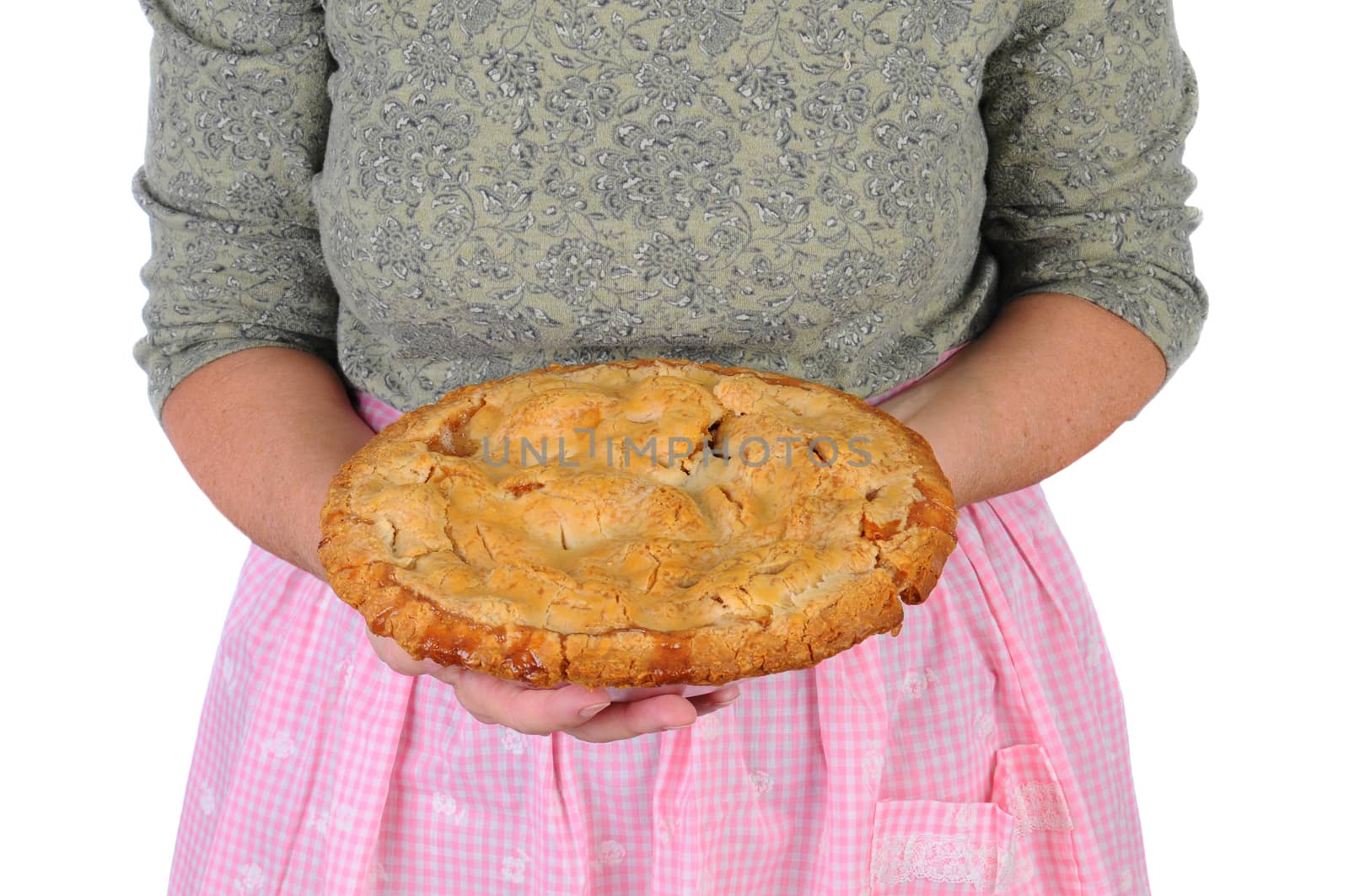 Closeup of a woman holding a freshly baked apple pie in front of her body. Woman is unrecognizable.