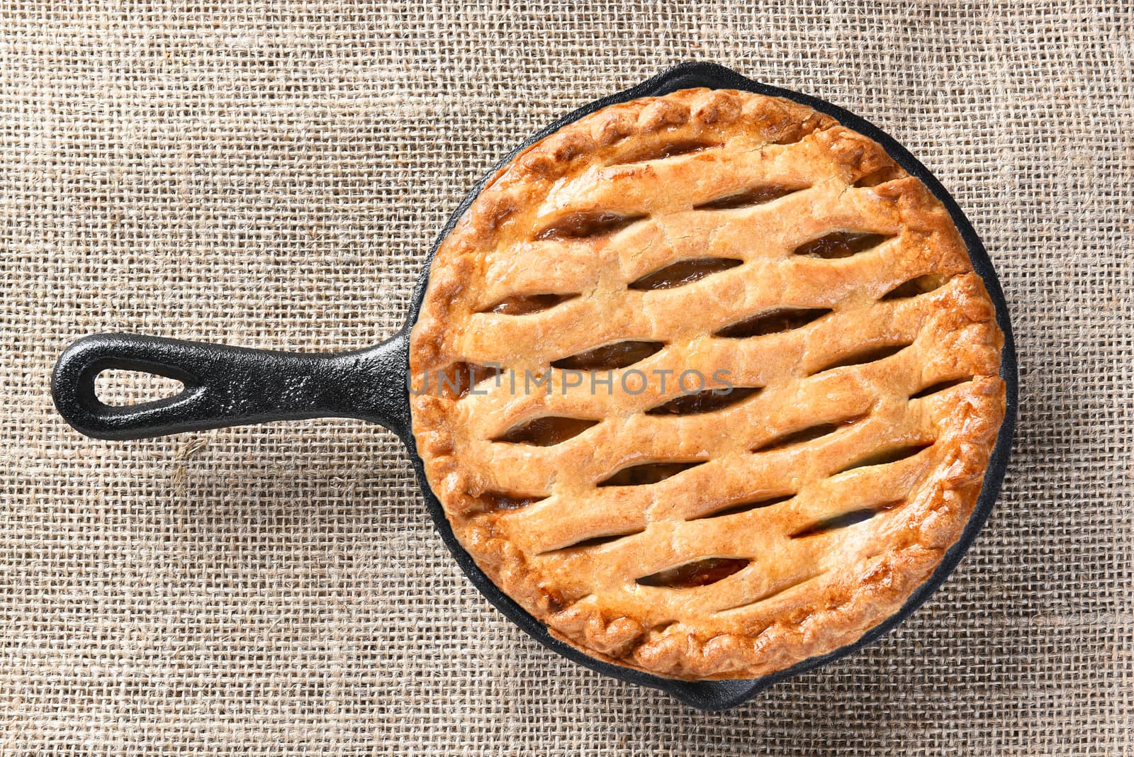 High angle view of a skillet baked apple pie n a burlap table cloth. 