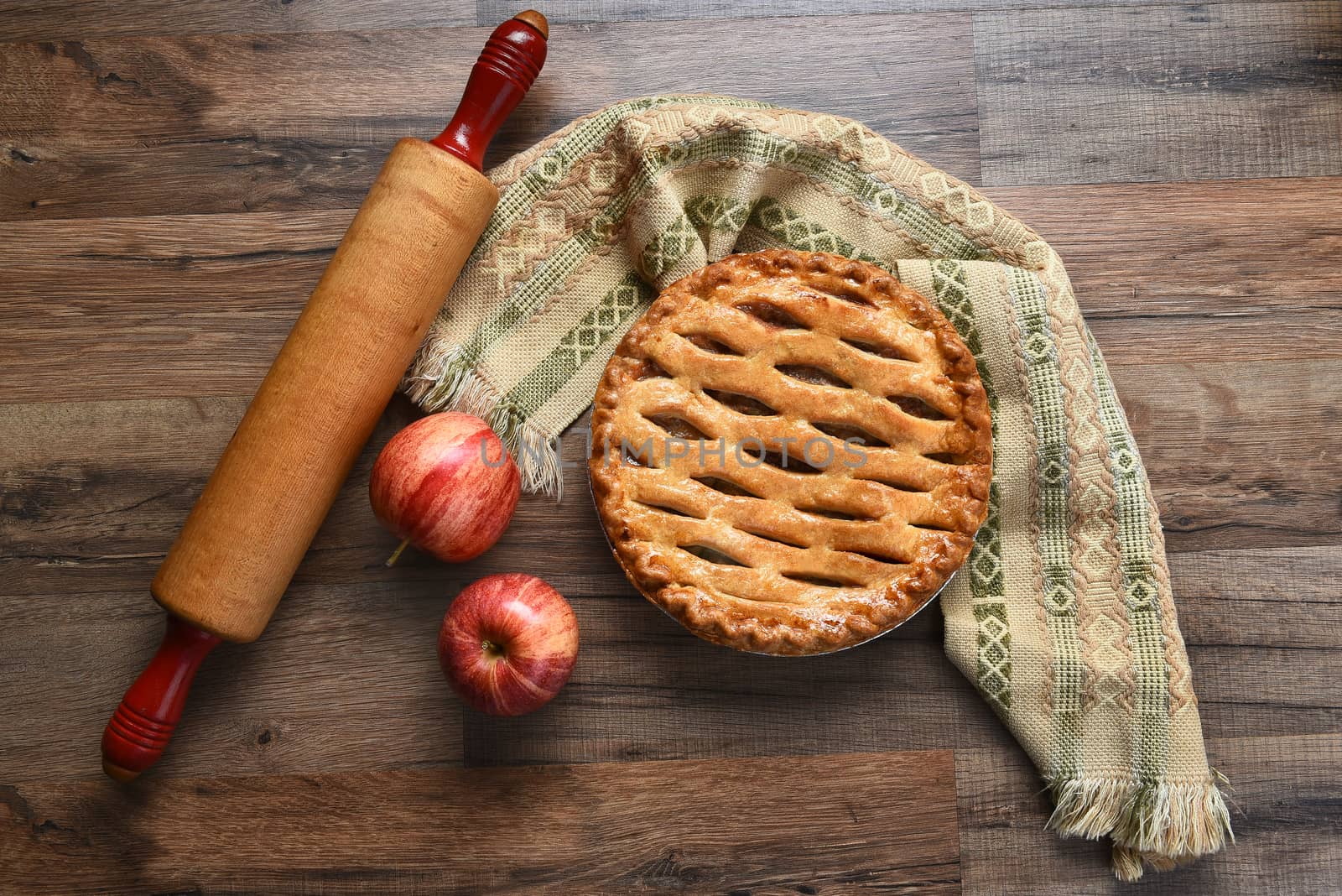 Apple pie still life with rolling pin and apples. High angle view with copy space.