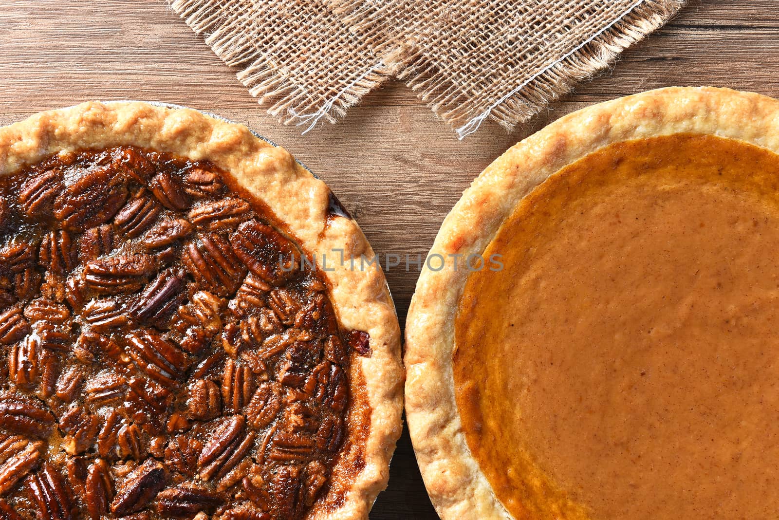 Closeup of two pies on a Thanksgiving holiday table. Pumpkin and pecan pies are traditional desserts for the American holiday.