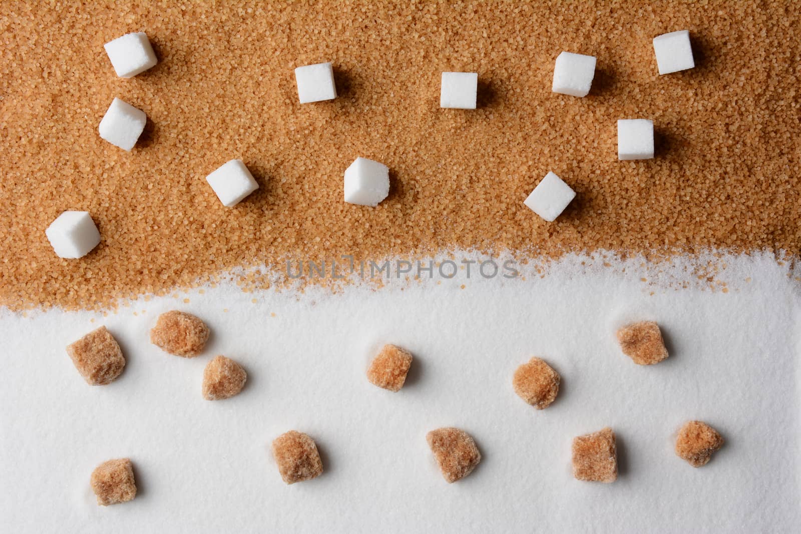 White and brown sugar contrast. White sugar cubes on raw brown turbinado granules and raw brown sugar lumps on white granulated sugar.