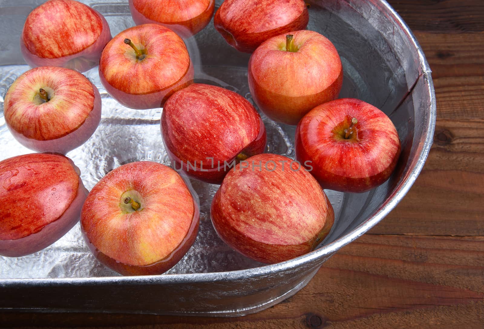 A metal tub filled with water and apples for the Halloween custom of Apple Bobbing.