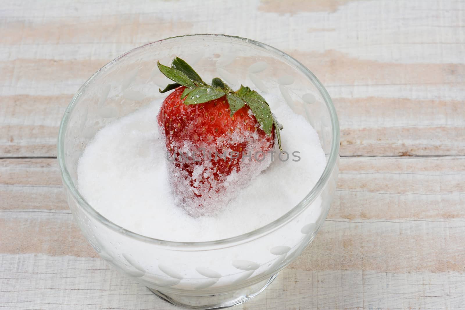 Closeup of a Fresh Strawberry in a Bowl of Sugar by sCukrov